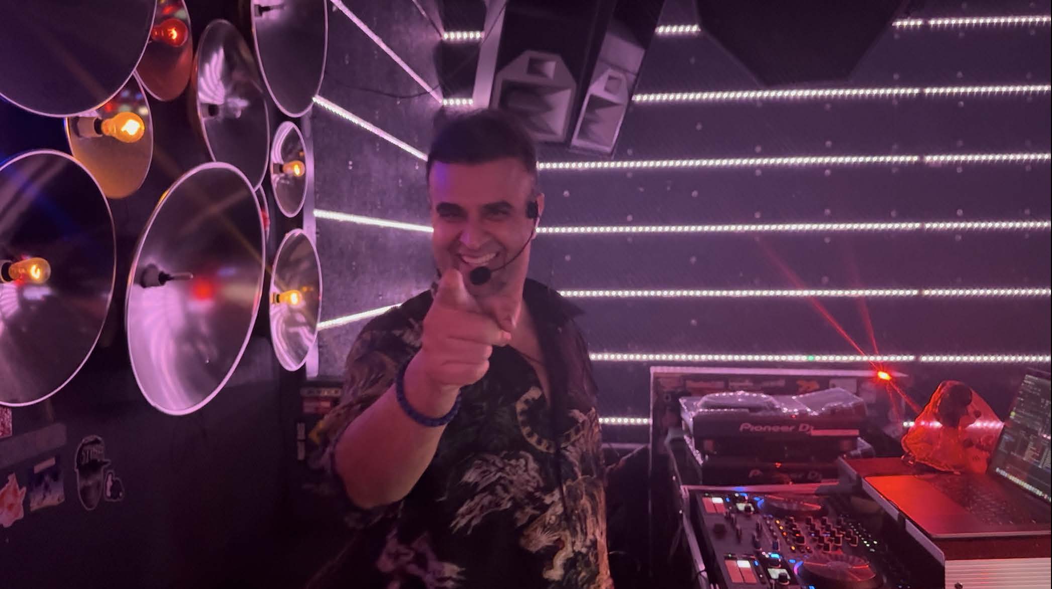 Nima Yazdanfar smiling while leading music with a headset microphone